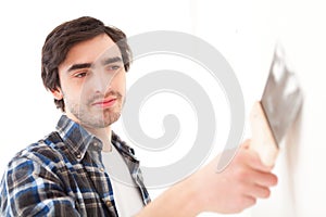 Attractive young man scrubing a wall in his flat