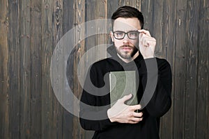 Attractive young man with a small beard in glasses and in black