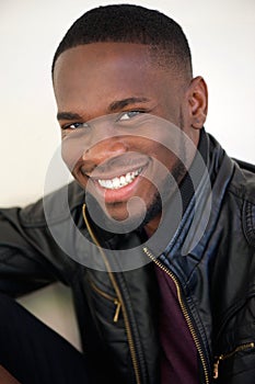 Attractive young man smiling in black leather jacket