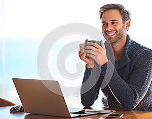 Attractive young man smiling while holding a coffee cup