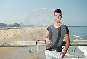 Attractive young man smiling at the seaside