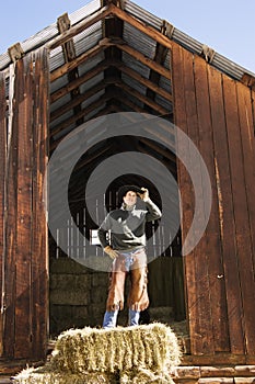 Attractive Young Man Standing on a Bale of Hay