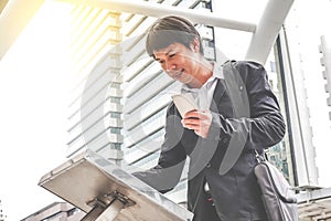 Attractive young man standing front big digital screen with basic tower map data with mobile.