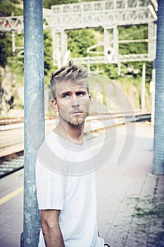Attractive young man standing on railroad tracks