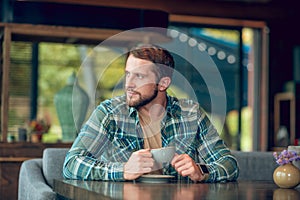 Attractive young man at table in cafe
