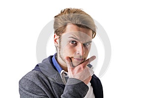 Attractive young man thinking, looking up with hand on his chin