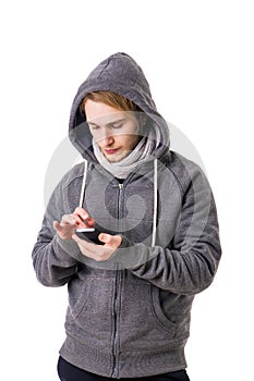 Attractive young man typing on smartphone, sending text message