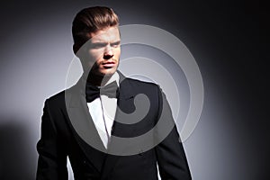 Attractive young man wearing elegant black suit and bow tie