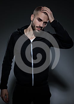 Attractive young man wearing gym suit on grey background