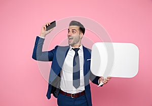 Attractive young man wearing navy blue suit on pink background