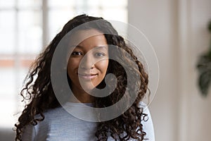 Attractive young mixed race black woman posing at home, portrait photo
