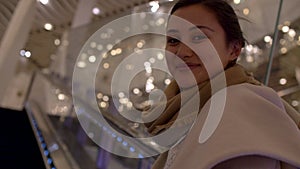 Attractive young mixed woman smiles on escalator closeup 4k