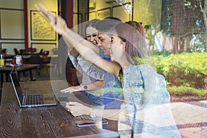 Attractive young people joining hands in cafe