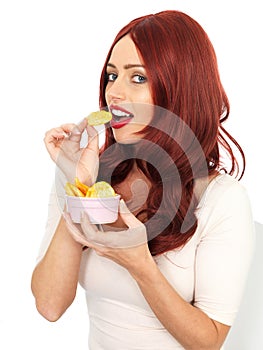 Attractive Young Red Haired Woman Eating Potato Crisps