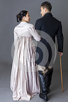 A Regency couple walking together against a grey backdrop photo