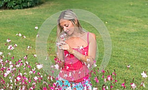 Attractive young smiling beautiful curly blonde hair slim girl fashion portrait in pink T-shirt posing looking away calm look, in