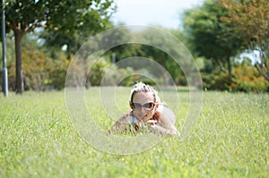 Attractive young smiling beautiful curly blonde hair slim girl fashion portrait in pink T-shirt posing looking away calm look, in