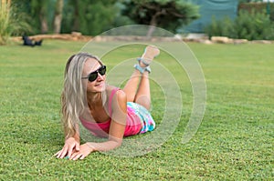 Attractive young smiling beautiful curly blonde hair slim girl fashion portrait in pink T-shirt posing looking away calm look, in