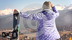 Attractive young snowboard girl smiling in camera with OK Gesture