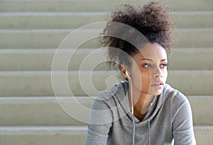 Attractive young sports woman sitting on steps with earphones