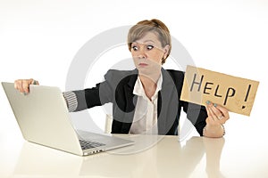 Attractive young stressed and frustrated business woman working on her computer asking for help