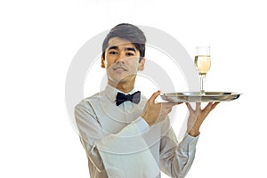 Attractive young waiter raised my head up and holding a tray with glasses of champagne