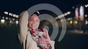 An attractive young woman acts a little shy then gives the camera a bit smile.