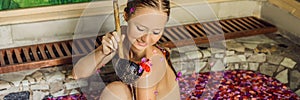 Attractive Young woman in bath with petals of tropical flowers and aroma oils. Spa treatments for skin rejuvenation