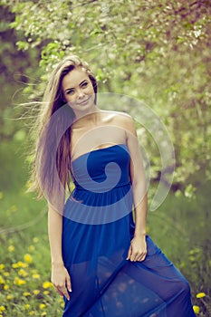 Attractive young woman in blue long dress outdoor portrait