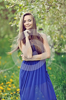 Attractive young woman in blue long dress outdoor portrait