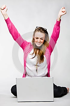 Attractive young woman celebrating with laptop