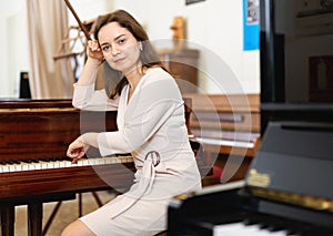 Attractive young woman chooses pianoforte in a record store