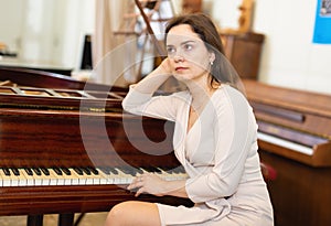 Attractive young woman chooses pianoforte in a record store