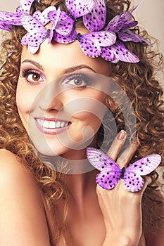 Attractive young woman with curly hairstyle and blue butterflies