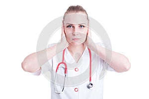 Attractive young woman doctor covering her ears with hands