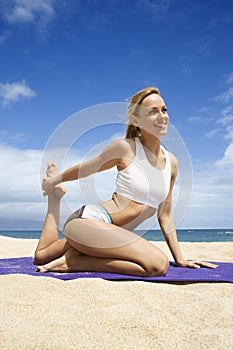 Attractive Young Woman Doing Yoga on Beach