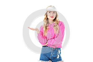 Attractive young woman dressed in pink presenting something