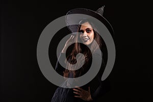 Attractive young woman dressedup like a witch for halloween with a big hat smiling photo