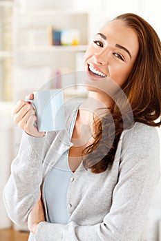 Attractive young woman drinking coffee at home