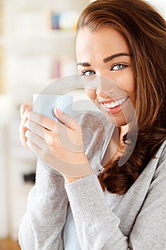 Attractive young woman drinking coffee at home