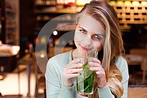 Attractive young woman drinking mint tea