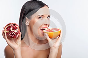 Attractive young woman is eating exotic fruit