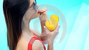 Attractive young woman enjoying cocktail at pool party, summer holidays