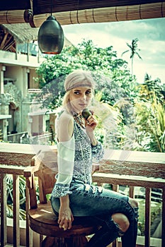 Attractive young woman in ethnic style look posing in tropical restaurant, portrait. Tropical island Bali, luxury resort