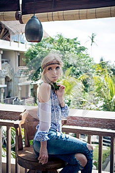 Attractive young woman in ethnic style look posing in tropical restaurant, portrait. Tropical island Bali, luxury resort