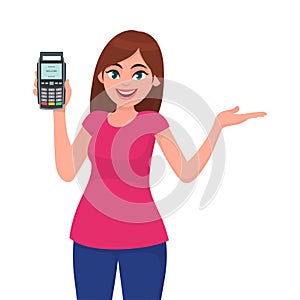 Attractive young woman/girl showing pos terminal or credit/debit cards swiping machine and gesture hand to copy space side away.