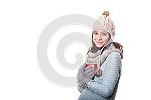 Attractive young woman in a gray T-shirt holding a glass of drink. Isolated on white background