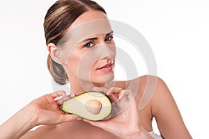 Attractive young woman holding avocado