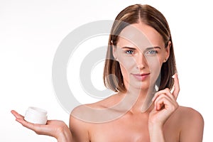 Attractive young woman holding cream