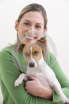 Attractive Young Woman Holding A Dog And Smiling